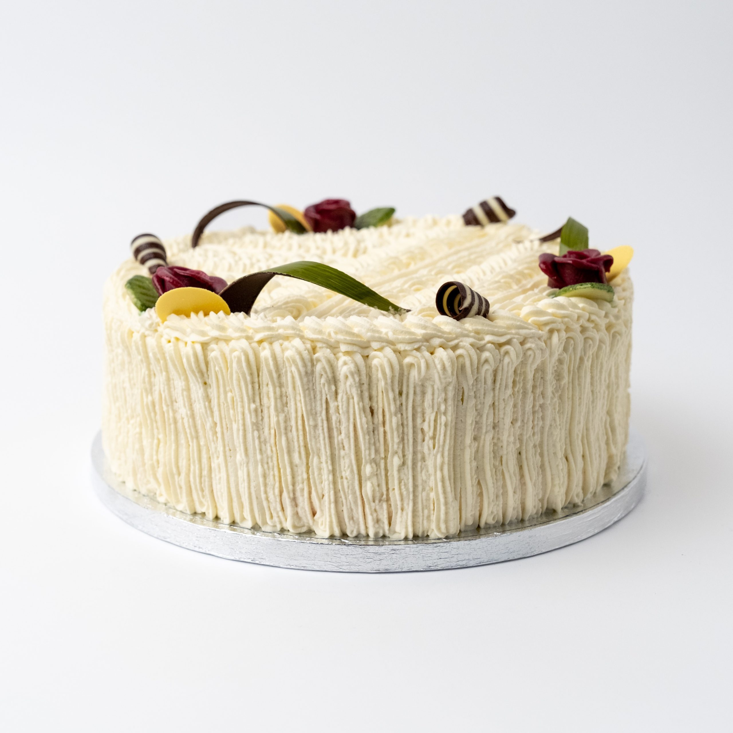 Fløtekake med sukkerbunn, krem og syltetøy, pyntet med marsipanskilt