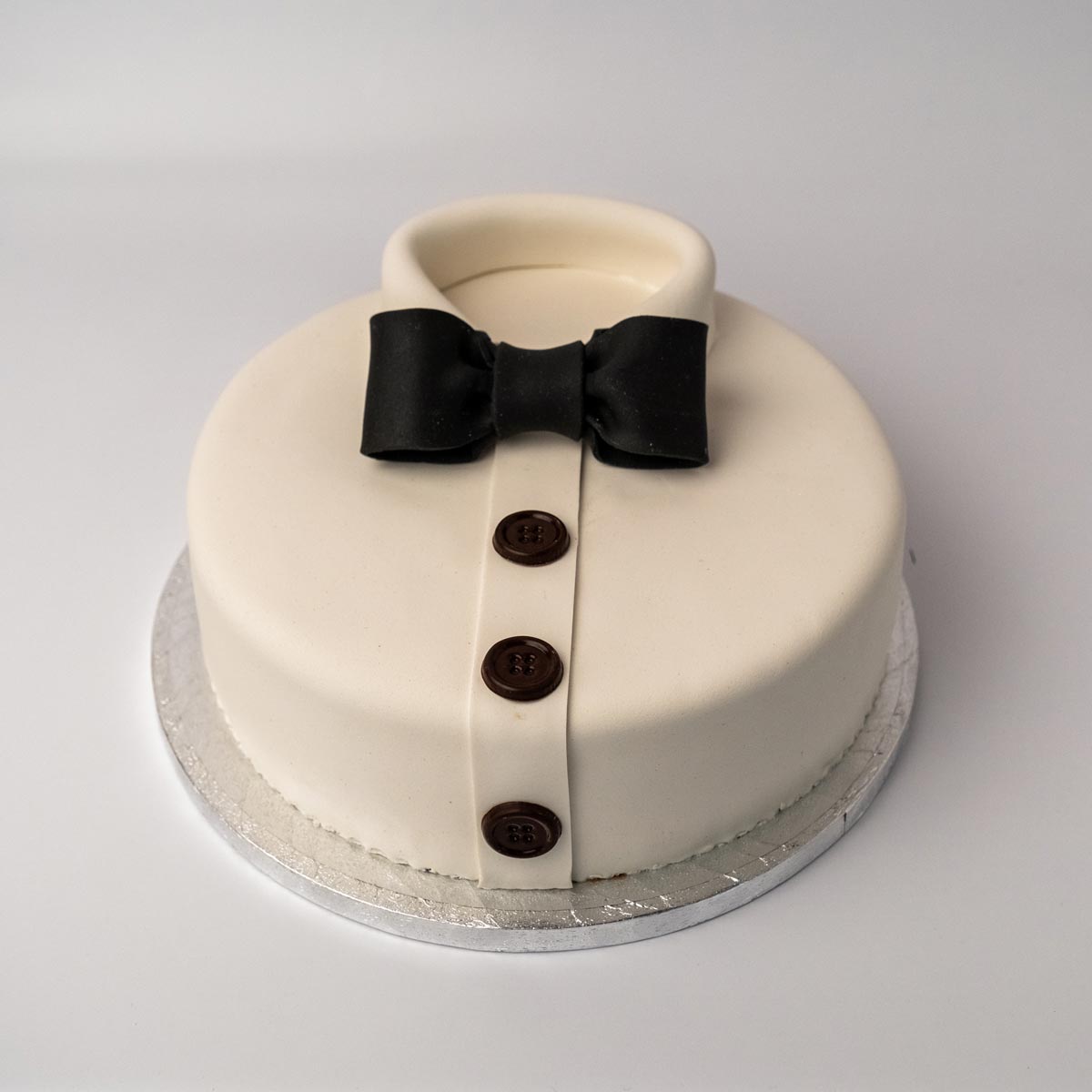 Skjortekake til guttekonfirmasjon med sløyfe, marsipan og sjokoladedekor